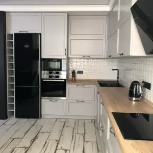 Белая кухня с черным холодильником